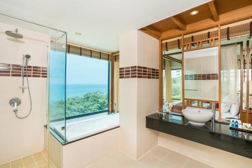 a bathroom with a glass shower and a sink at Cosy Beach Hotel - SHA Extra Plus in Pattaya South