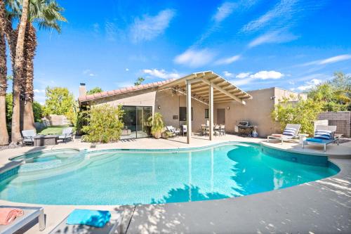 a swimming pool with chairs and a house at California Dreamin' in Palm Springs
