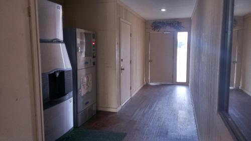 a room with a hallway with a refrigerator and a door at Green bird Inn in Vernon