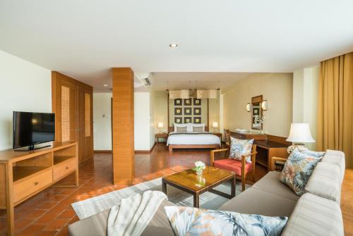 a living room with a couch and a room with a bed at Cosy Beach Hotel - SHA Extra Plus in Pattaya South