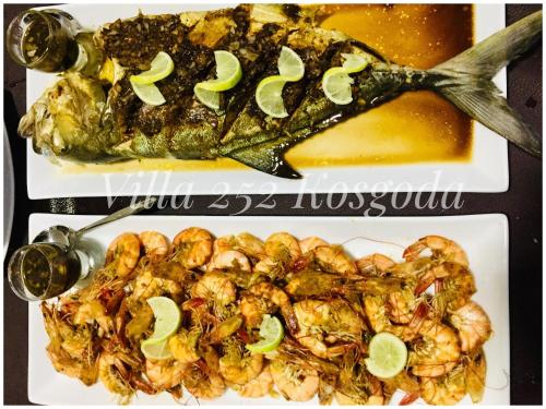 a plate of food with a fish with lime slices on it at Villa 252 Kosgoda in Kosgoda