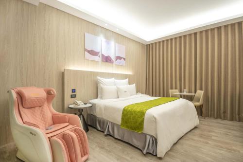 Habitación de hotel con cama y silla en 168 Motel-Taoyuan, en Taoyuan