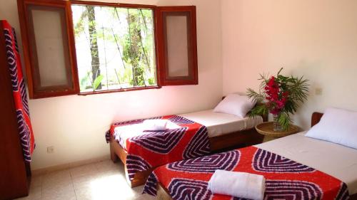 um quarto com duas camas e uma janela em Kasa KAÏSSAKU Idéale pour Surfeurs et Kitesurfeurs em Kafountine