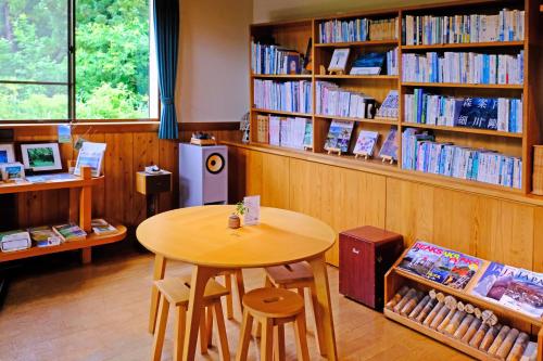 a library with a table and shelves of books at Nabekura Kougen Mori-No-Ie in Iiyama