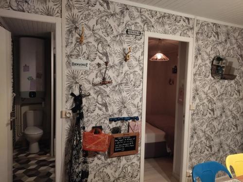 un pasillo con una pared cubierta de papel pintado en la cabane des druides, en Périgny