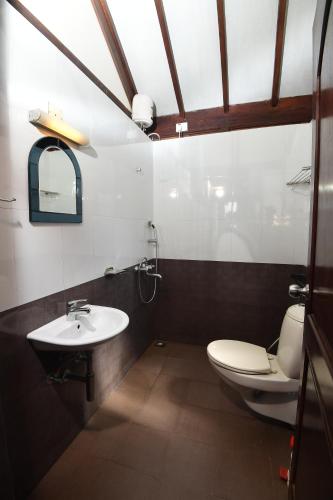 a bathroom with a toilet and a sink at Bluewater Beach Resort in Varkala