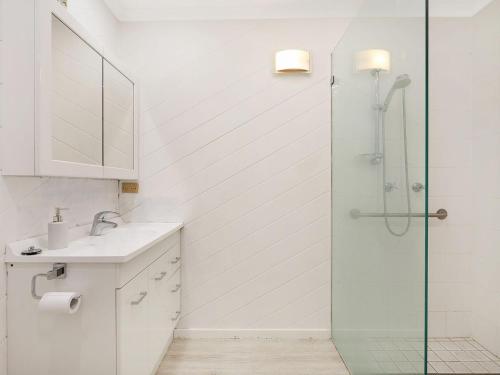 a bathroom with a shower and a sink at Kianga Parade Beach House in Kianga