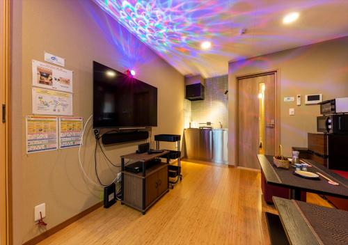 a room with a kitchen with a neon ceiling at YADOYA Yumeji in Tokyo
