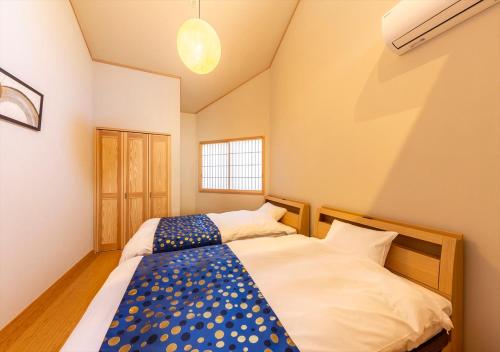 a bedroom with two beds and a window at YADOYA Yumeji in Tokyo