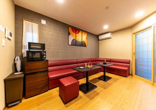 a living room with a red couch and a tv at YADOYA Yumeji in Tokyo