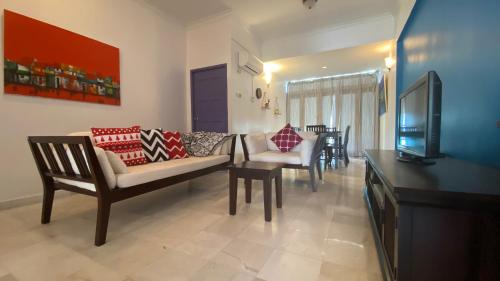 uma sala de estar com um sofá e uma televisão em Sugar Marina Seaview Families Suite Apartment em Kuah