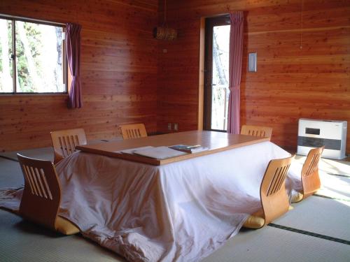 a dining room with a table and chairs in a cabin at Nabekura Kougen Mori-No-Ie in Iiyama