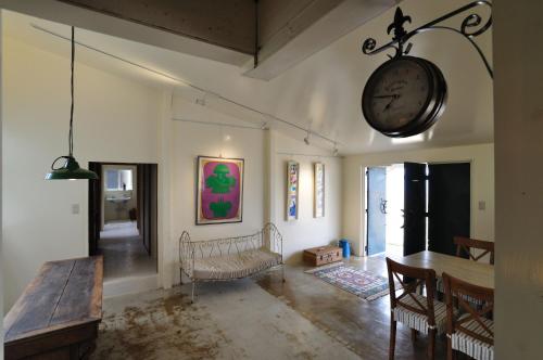 a living room with a clock on the wall at Megijima Beach Apartment in Takamatsu