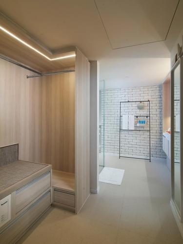 a bathroom with a walk in shower and a glass door at Shama Yen-Akat Bangkok in Bangkok