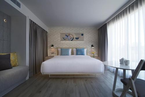 a bedroom with a large bed and a table at Shama Yen-Akat Bangkok in Bangkok