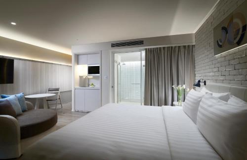 a bedroom with a large white bed and a living room at Shama Yen-Akat Bangkok in Bangkok