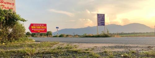 a street with two signs on the side of the road at Hương Tràm Homestay in Hồ Ðá