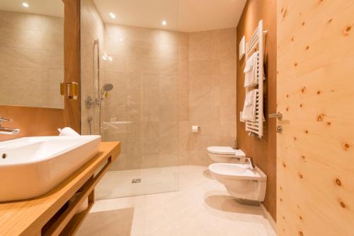 uma casa de banho com 2 WC, um lavatório e um chuveiro em Hotel Panorama em Fleres