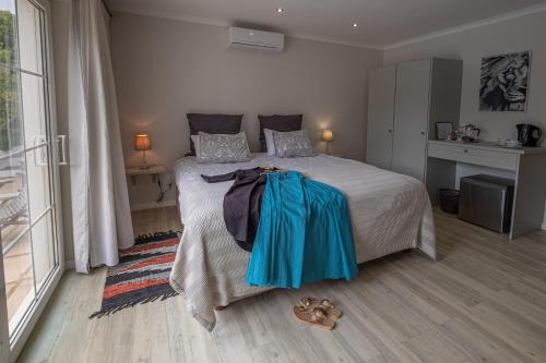 a bedroom with a large bed with shoes on the floor at Eden Studios in Riebeek-Kasteel
