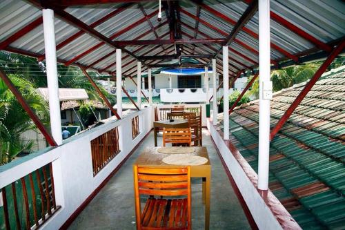 un patio con mesas y sillas en un barco en Viraj's Garden, en Tangalle