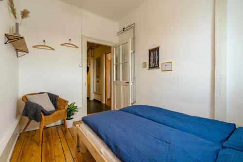 una camera con un letto blu e una sedia di Eigene Wohnung im Stadtzentrum mit wunderschöner Dachterrasse a Biel