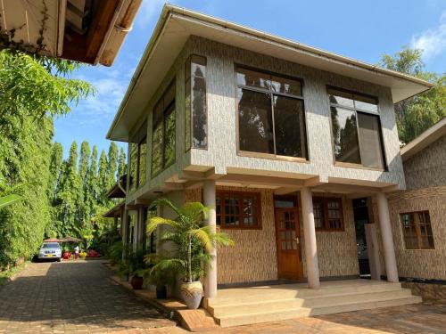 a house with a car parked in front of it at Sangana Lodge in Moshi