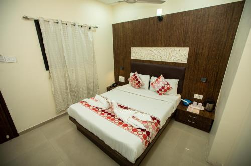 a bedroom with a large bed with red and white pillows at Hotel J D Residency in Mumbai