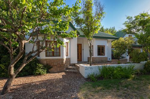 a white house with a tree in front of it at Eden Studios in Riebeek-Kasteel