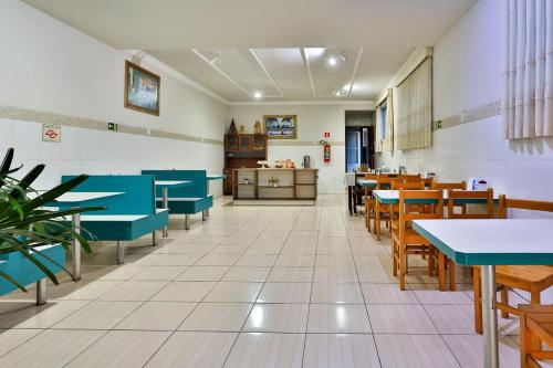un comedor con mesas y sillas azules en Hotel Romaria Aparecida en Aparecida