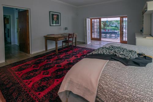 a bedroom with a bed and a desk and a table at Eden Studios in Riebeek-Kasteel