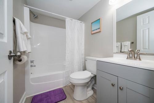 a white bathroom with a toilet and a sink at Spacious and Cozy 2BR with Parking in Durham