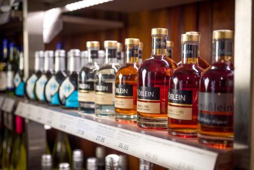 a row of bottles of alcohol on a shelf at Spundloch- das Hotel & Weinrestaurant in Veitshöchheim