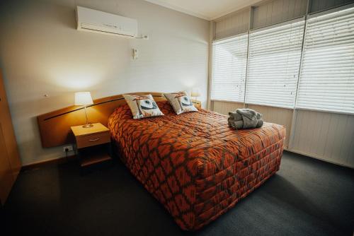 a hotel room with a bed with a backpack on it at Seasons Hotel Newman in Newman