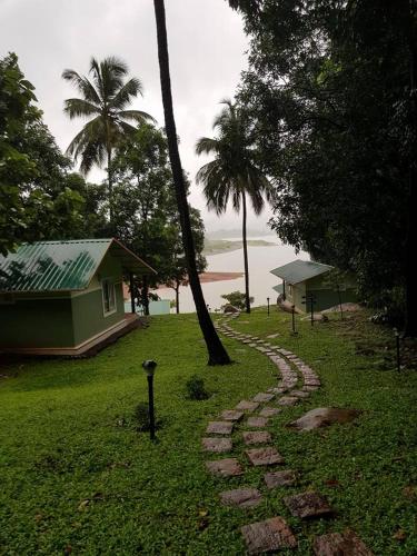 a stone path in the grass next to a house at Diga vista resorts in Palakkad