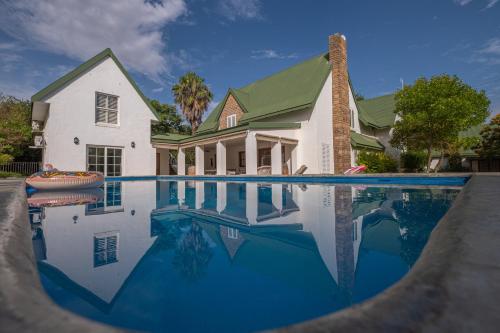 une maison avec une piscine en face d'une maison dans l'établissement Eden Studios, à Riebeek-Kasteel