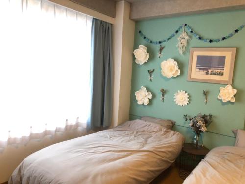 a bedroom with a bed and flowers on the wall at Upper Hotel Ishihara in Tokyo