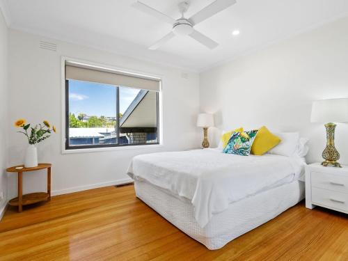 een witte slaapkamer met een groot bed en een raam bij Maybloom in Rye