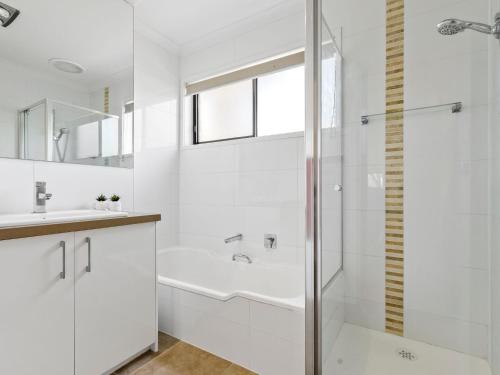 een witte badkamer met douche en wastafel bij Maybloom in Rye