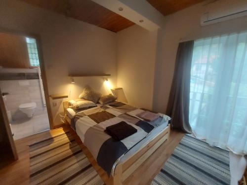 a bedroom with a large bed and a large window at Attila's Guest House in Budaörs