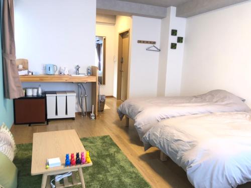 a room with two beds and a table in it at Upper Hotel Ishihara in Tokyo