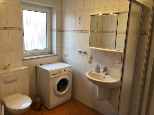 a bathroom with a washing machine and a sink at Schulstrasse 10a Fewo in Zingst