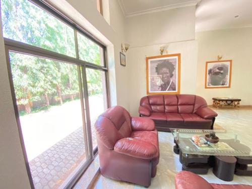 a living room with two leather chairs and a table at Sangana Lodge in Moshi