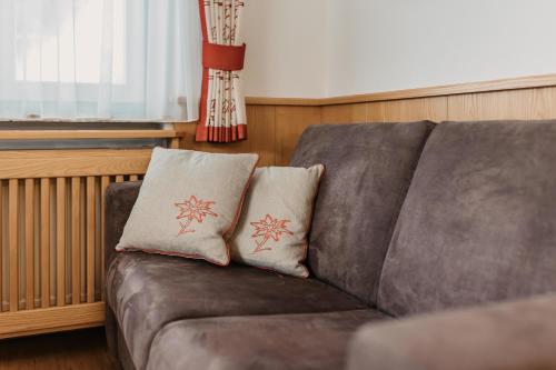 a brown couch with two pillows on it at Landhaus Rohrmoser in Werfenweng