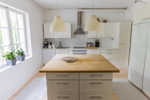 a kitchen with white cabinets and a wooden counter top at Villa Tammikko in Tuusula