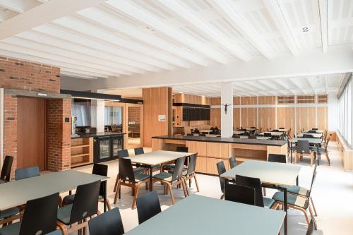 a dining room with tables and chairs and a kitchen at Cusanus Akademie - Accademia Cusanus in Bressanone