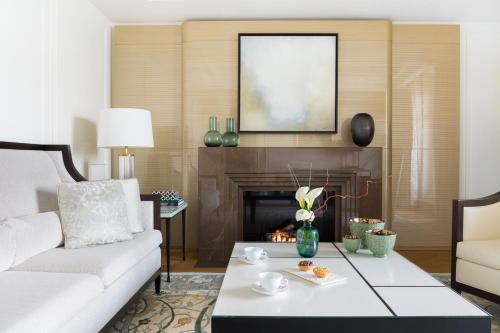 a living room with a white couch and a fireplace at The Woodward - an Oetker Collection Hotel in Geneva