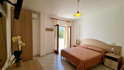 a bedroom with a bed and a table and a window at Cocos Park Ischia in Ischia