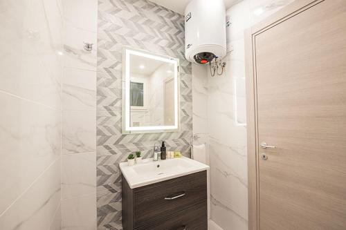 uma casa de banho com um lavatório e um espelho em Atlantis Holiday Suites em Marsalforn