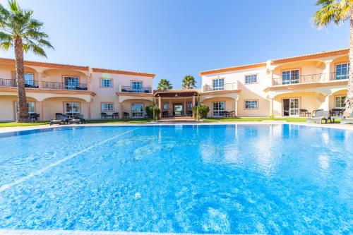 a large swimming pool in front of a building at Atalaia Sol Aparthotel - tennis & heated pool in winter in Lagos