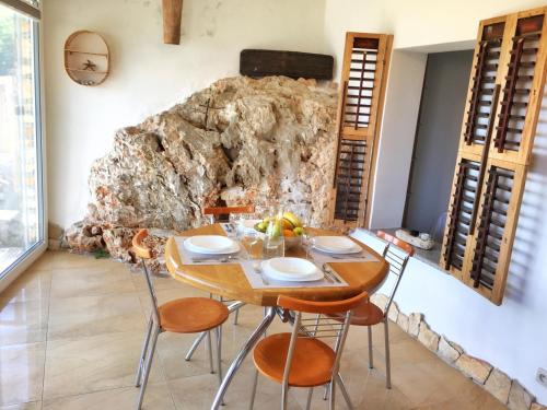 a table and chairs in a room with a stone wall at Brestova Sun in Zagorje